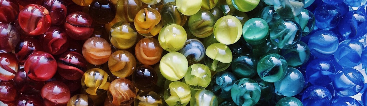 A selection of coloured marbles organised by colour